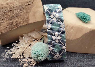 CHERIE POP Bracelet tisse AZURA 01 presente sur son socle avec des fleurs sechees bleues et blanches